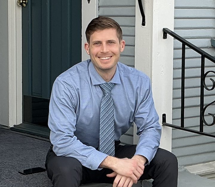Dr. Sean Marsh, D.C., smiling on the front steps of the office